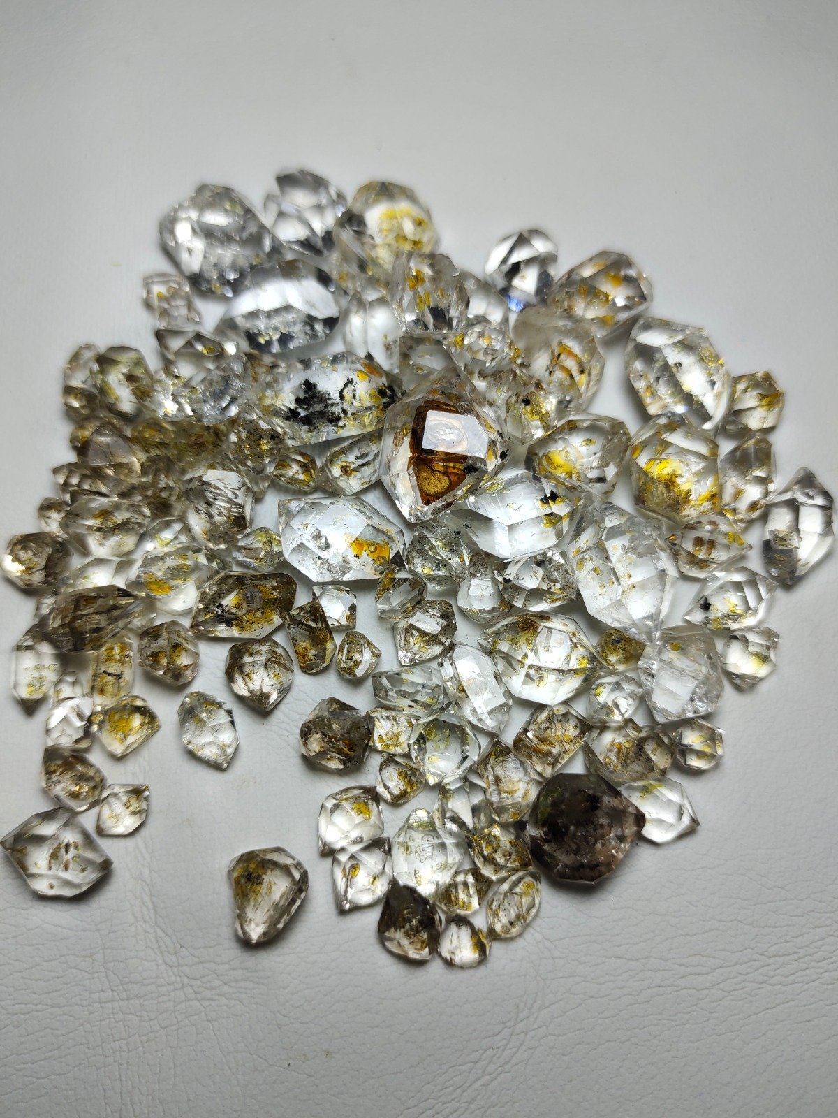 Pile of Herkimer diamond quartz crystals with golden inclusions